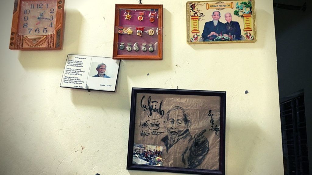 Bức tường treo ch&acirc;n dung v&agrave; hu&acirc;n, huy chương của &ocirc;ng L&ecirc; Đ&igrave;nh K&igrave;nh, c&ugrave;ng với dấu vết đạn bắn. Ảnh: May/Luật Khoa.
