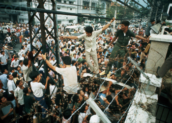 Người dân trèo qua bức tường cao của Đại sứ quán Mỹ ở Sài Gòn. Họ cố gắng tìm lối thoát khi những người Mỹ cuối cùng dần di tản khỏi Việt Nam. Nguồn ảnh: AP.